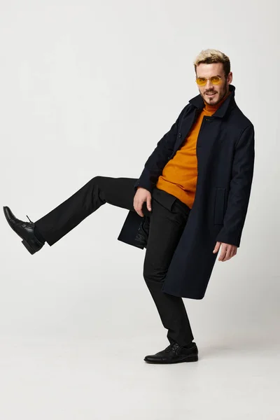 Tipo enérgico con gafas y un abrigo de suéter naranja gesto con las manos — Foto de Stock