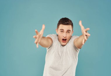 Yakışıklı bir adam elleri ve duyguları ile hareket ediyor. Yaşam tarzı mavi arka plan