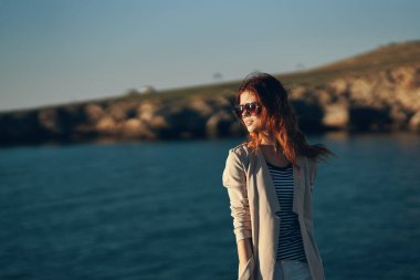 Sahilde yürüyen gözlüklü bir manken. Garaj manzaralı deniz kenarında.