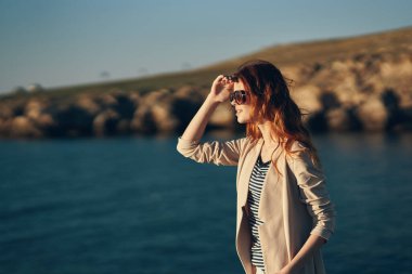 Sahilde yürüyen gözlüklü bir manken. Garaj manzaralı deniz kenarında.