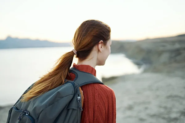 Руда жінка з рюкзаком на спині ходить у природі в горах з рюкзаком на спині — стокове фото