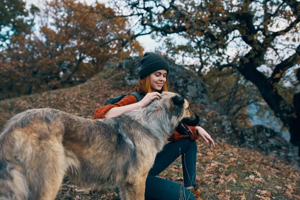 Mulher com mochila ao lado de cão amizade natureza viagens férias — Fotografia de Stock