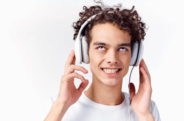 Gelukkig guy met koptelefoon krullend haar emoties close-up — Stockfoto