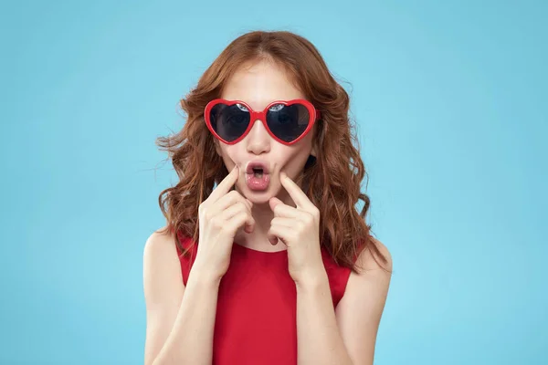 Lustiges Mädchen in einem roten Kleid lockiges Haar Lächeln blauer Hintergrund — Stockfoto