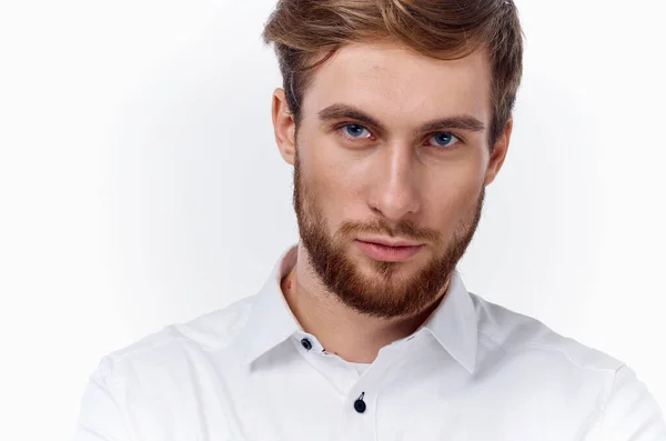 Homme blond avec une barbe épaisse et une moustache dans une chemise blanche sur un fond clair — Photo