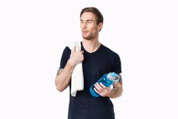 Homem em t-shirt preta com garrafa de água na mão e toalha no ombro vista cortada — Fotografia de Stock