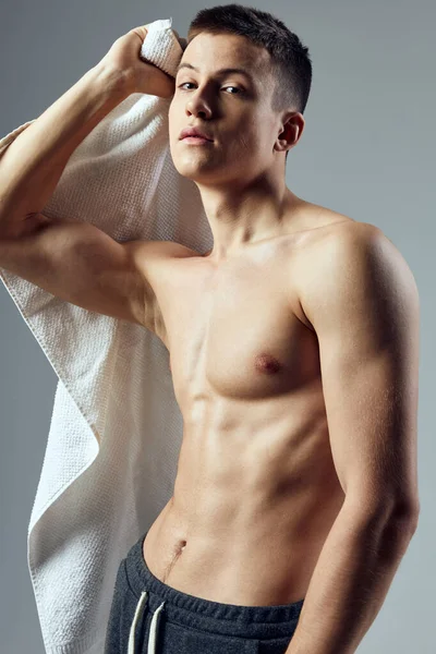 Homem atlético com um torso bombeado toalha branca fitness lifestyle — Fotografia de Stock