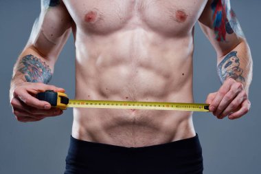 Kolunda santimetre bant, vücut geliştirme modeli dövmesi olan sevimli bir sporcu.