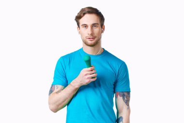 Elinde dambıl, elinde kulaklık, spor salonu olan bir adam.