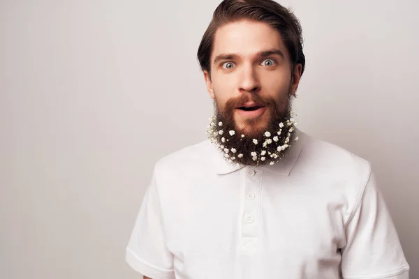 Веселый мужчина цветы в бороде украшения эмоции белая футболка — стоковое фото
