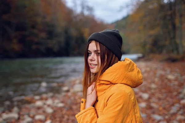 Mujer camina en el bosque de otoño en una chaqueta amarilla montañas viaje —  Fotos de Stock