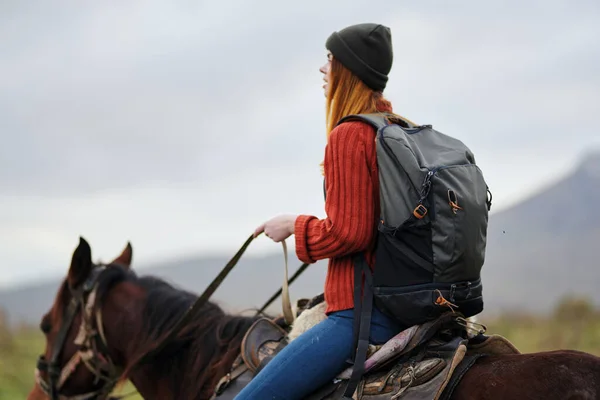 woman hiker with backpack riding horse travel freedom