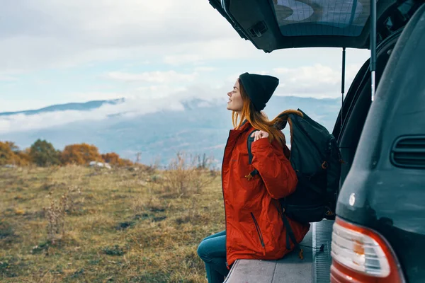 Молодой путешественник рядом с автомобилем осенью в горах — стоковое фото