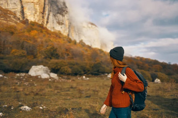 Γυναίκα σε ένα πουλόβερ με σακίδιο βόλτες το φθινόπωρο στα βουνά υπαίθρια αναψυχής μοντέλο διακοπές — Φωτογραφία Αρχείου