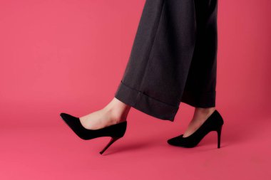 Kadın ayakları siyah ayakkabılar kırpılmış pembe arka plan modern tarz cazibe