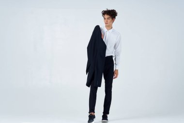 Elinde ceketi olan, modaya özgüveni olan bir adam.