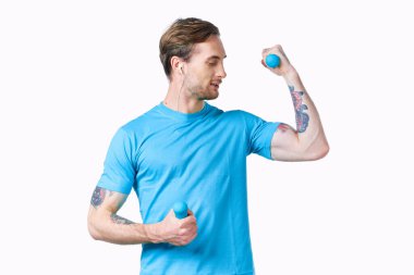 Kollarında dövmeleri olan bir makine ve mavi halterli vücut geliştiriciler.