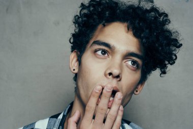 Yakışıklı adam portresi kıvırcık saçlı duygular gri arka plan modeli