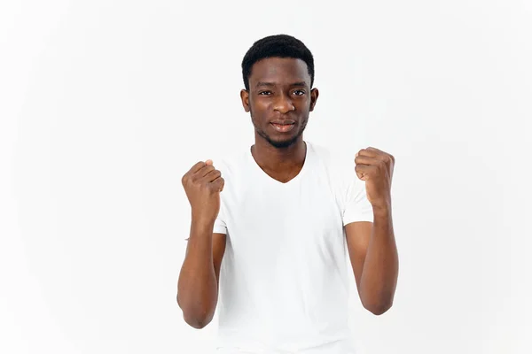 Hombre de apariencia africana en gestos de camiseta blanca con manos emociones estilo moderno — Foto de Stock