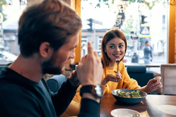 Emotionele mannen en vrouwen aan een tafel in een café plezier getrouwd koppel maaltijd salade — Stockfoto