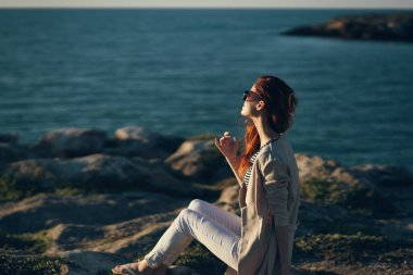 Kadın nehir kıyısında, dağlarda, kumsalda yaz manzarası, temiz hava.