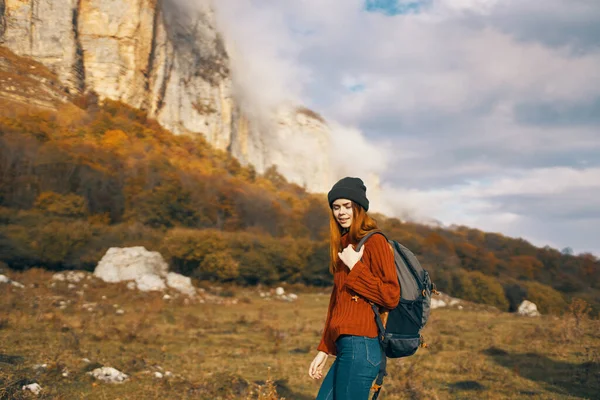 Jolie femme avec un sac à dos à l'automne dans les montagnes jeans chapeau loisirs relax — Photo