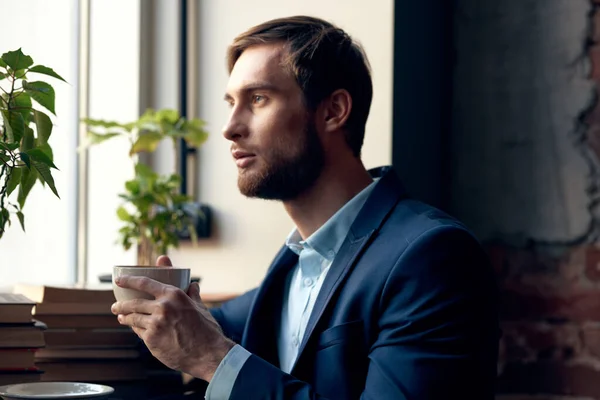 Homem em um terno com uma xícara de café em suas mãos café da manhã lazer estilo de vida — Fotografia de Stock