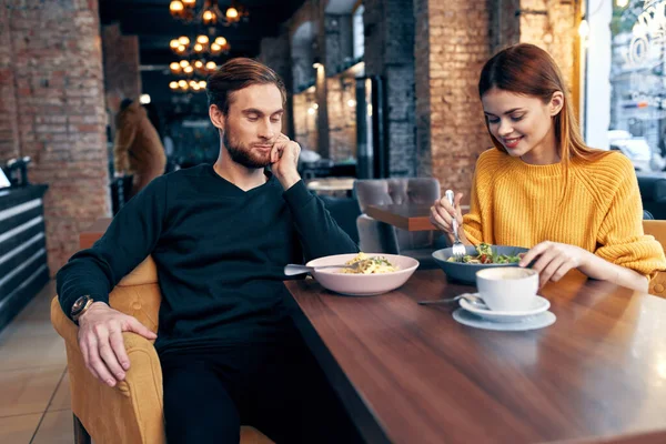 Alegre jovem casal sentado em um restaurante descansar comendo — Fotografia de Stock