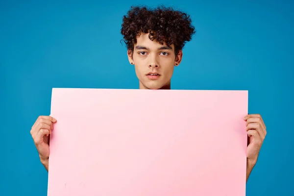 핑크 포스터를 달고 파란 배경을 흉내낸 감성적 인 남자 — 스톡 사진