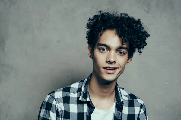 Cheerful guy curly hair and plaid shirt modern style studio model — Stock Photo, Image