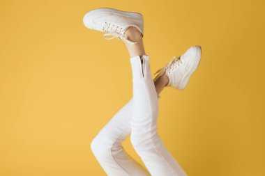 Beyaz spor ayakkabılı ters bacaklar modern stil sarı arka plan