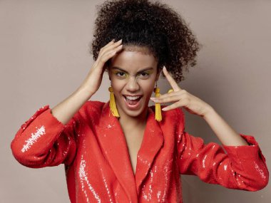 Kıvırcık saçlı, kırmızı ceketli, lüks duyguları olan bir kadın.