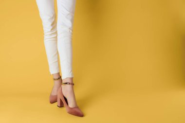 Poz veren kadın ayakları moda sezonu sarı arka plan