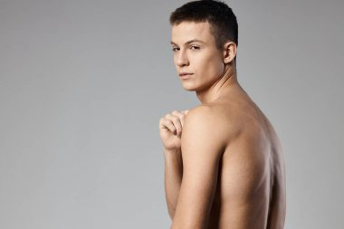 Kol kasları şişmiş, sırtı gri, güçlü bir sporcu.