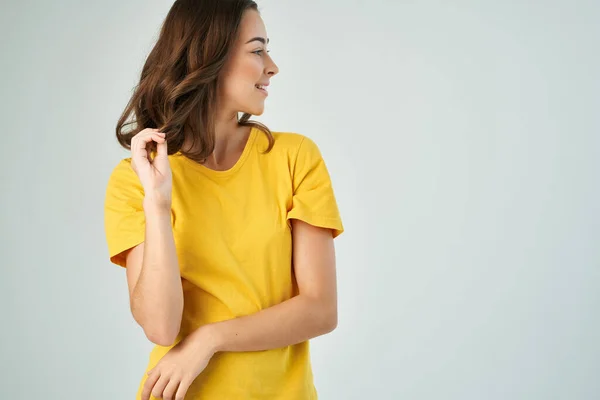 Cheerful brunette in yellow t-shirt fashion hairstyle glamor cropped view studio — Stock Photo, Image