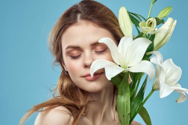 Çıplak omuzlu kadın çiçekleri çekici kılar.