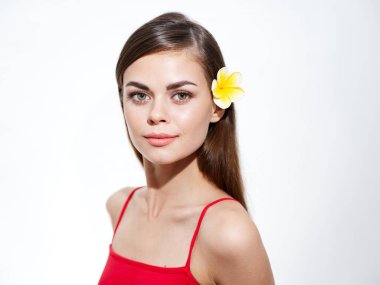 Sarı çiçekli, sarı saçlı ve kırmızı omuzlu güzel esmer kadın.