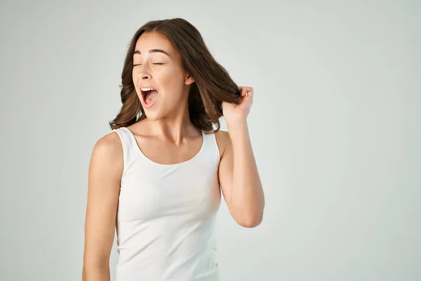 Morena en camiseta blanca endereza su peinado recortado vista aislado fondo — Foto de Stock