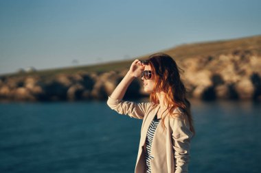 Sahilde yürüyen gözlüklü bir manken. Garaj manzaralı deniz kenarında.