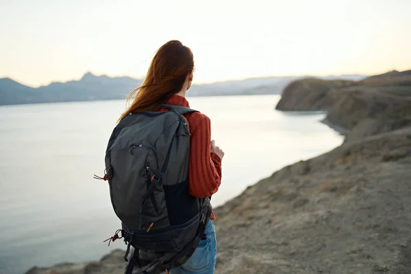 Turismo di viaggio giovane donna con zaino in riva al mare in montagna natura — Foto Stock