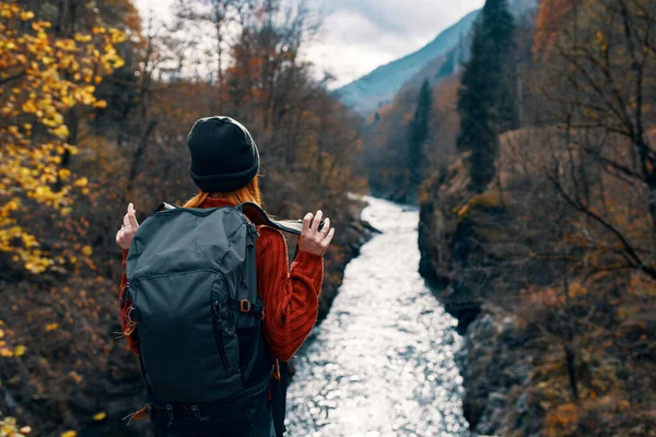 Kvinna vandrare med ryggsäck i bergen höst skog — Stockfoto