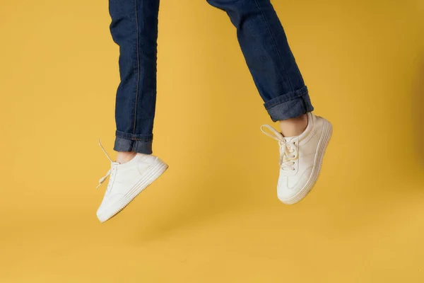 Weibliche Füße abgeschnitten Ansicht weiße Schuhe Mode gelb Hintergrund — Stockfoto