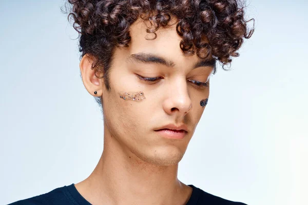 Handsome man with curly hair black cosmetics hand gesture — Stock Photo, Image