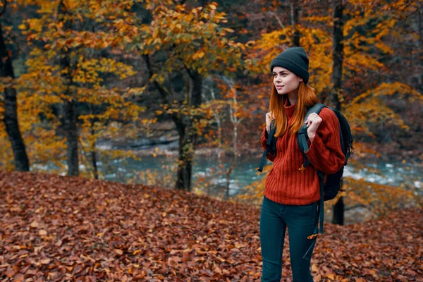 Podzim park spadl listí vysoké stromy řeka v pozadí a žena cestovní ruch — Stock fotografie