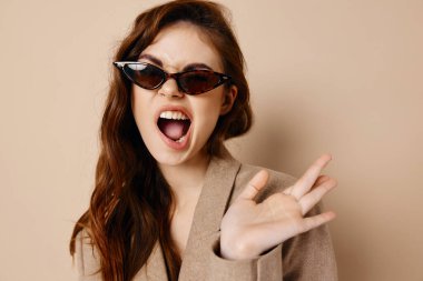 energetic woman with glasses and beige coat hairstyle wide open mouth
