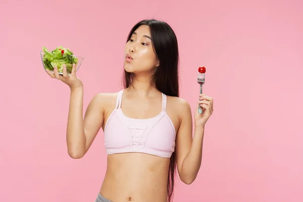 Mujer con una figura delgada sosteniendo un plato de ensalada en su dieta de la mano calorías pérdida de peso —  Fotos de Stock