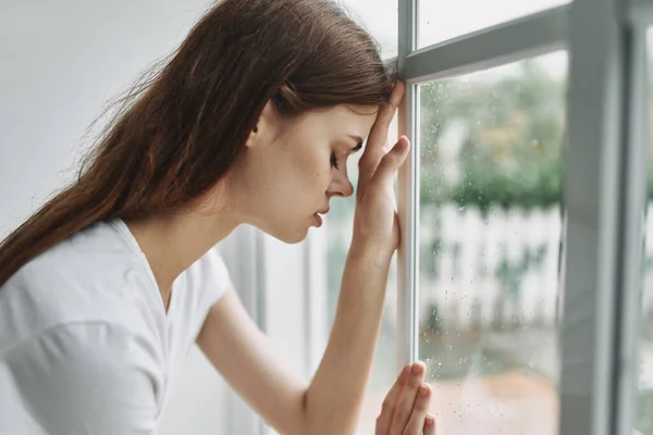 Mulher triste apoiando-se na janela de vidro e triste quarto modelo rosto — Fotografia de Stock