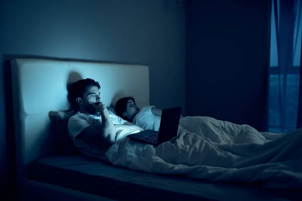Młoda para w łóżku nocnym z laptopem technologia spędzania wolnego czasu — Zdjęcie stockowe