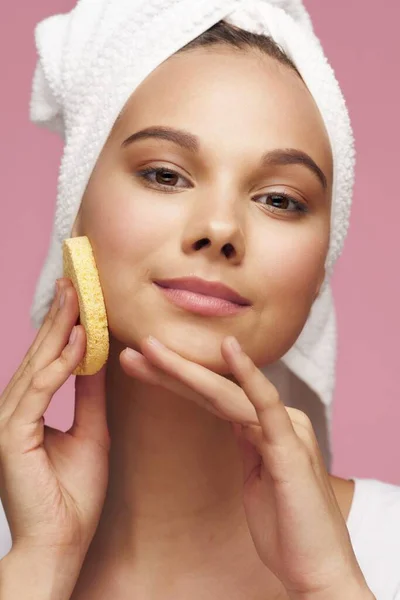 Woman wipes her face with a sponge clean skin cosmetology model thick eyebrows makeup towel on head — Stok Foto