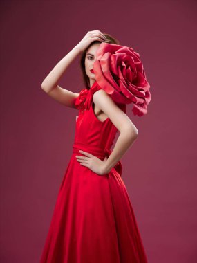 romantic people in a red dress with a decorative flower on the shoulder On a bright background